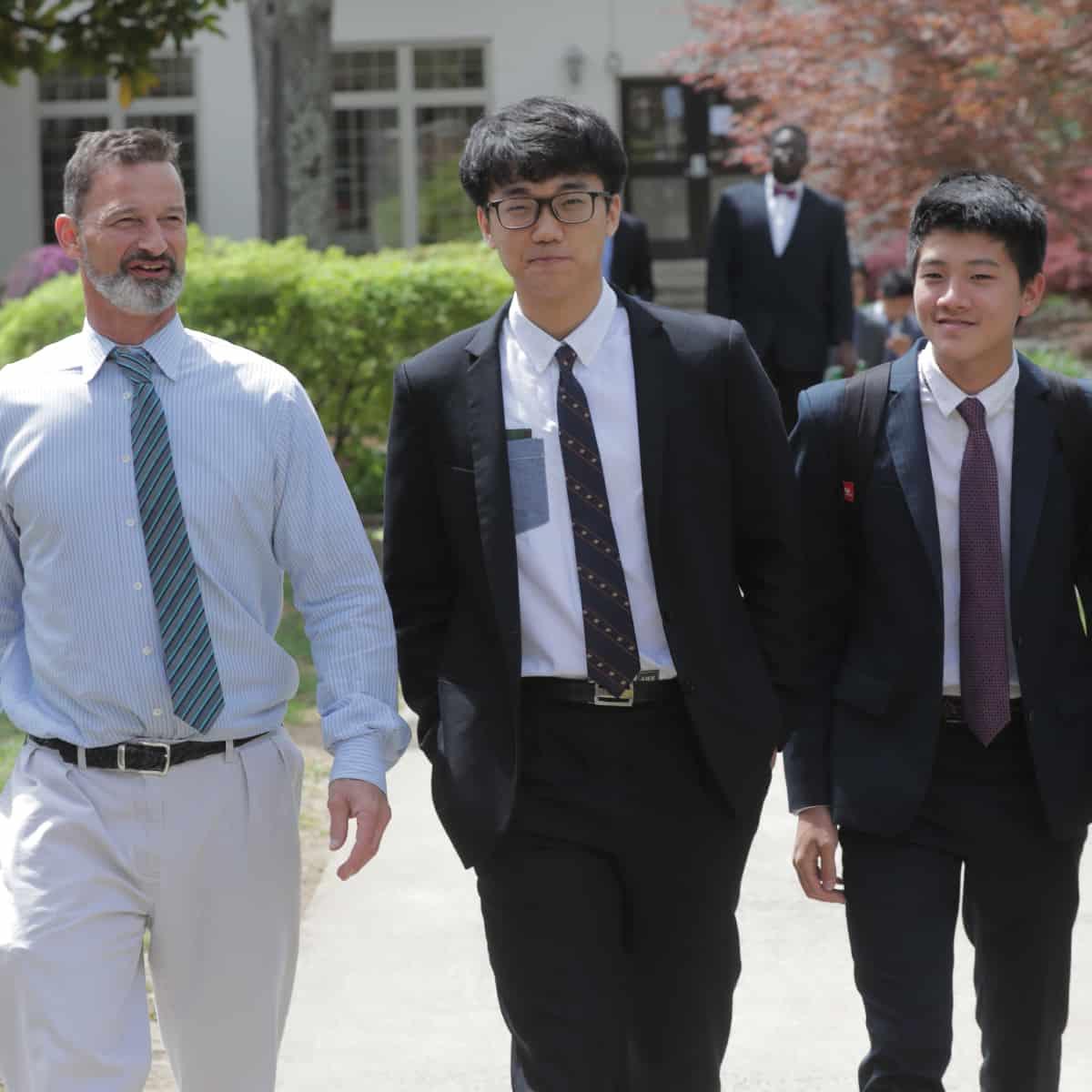 Students and teacher walking on the sidewalk